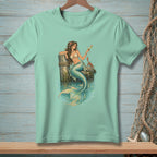 Mint t-shirt with a mermaid holding a drink next to a crab on a dock.