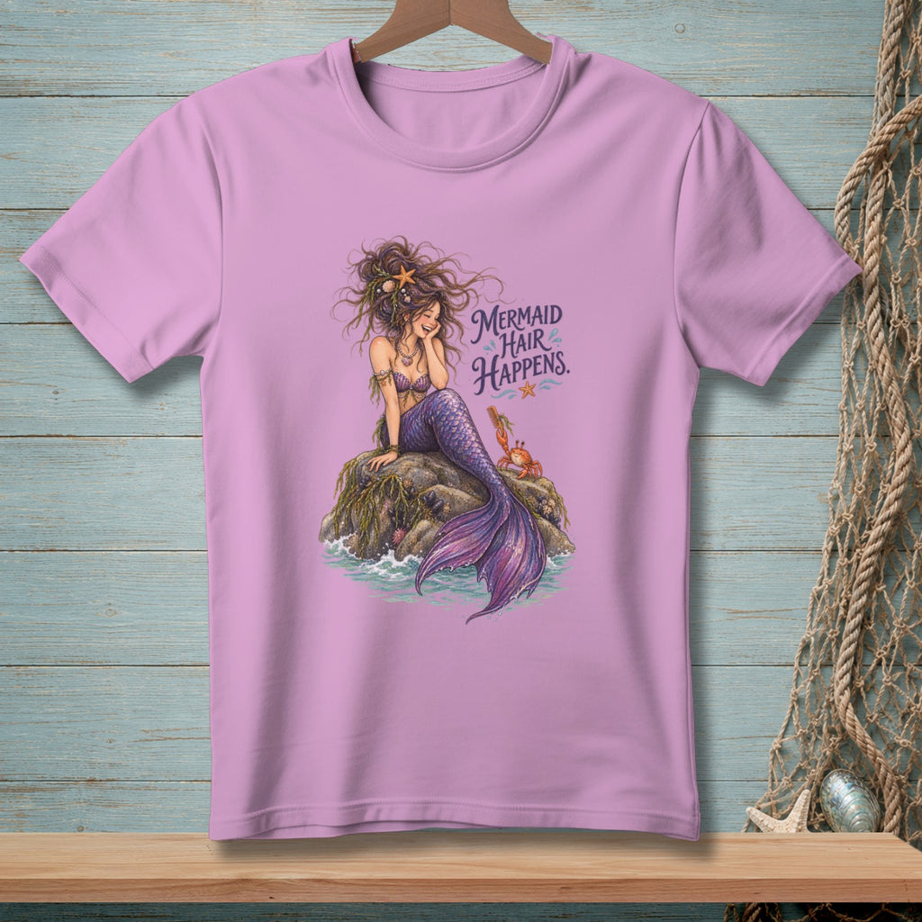 Lilac t-shirt with graphic of mermaid sitting on a rock with text "Mermaid Hair Happens".