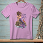 Lilac t-shirt with graphic of mermaid sitting on a rock with text "Mermaid Hair Happens".