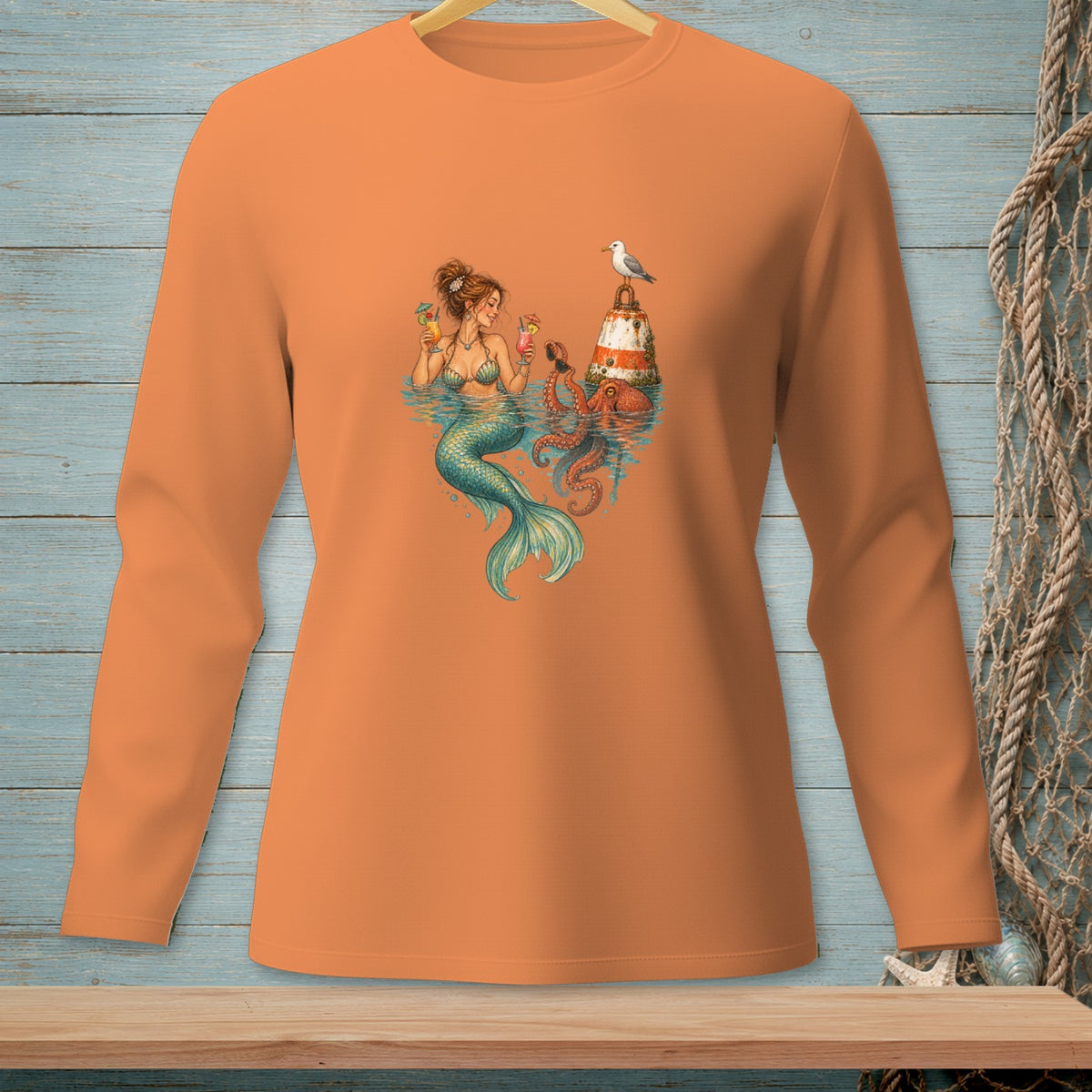 Mermaid with octopus and lighthouse drinking cocktails, on an orange long-sleeve shirt.