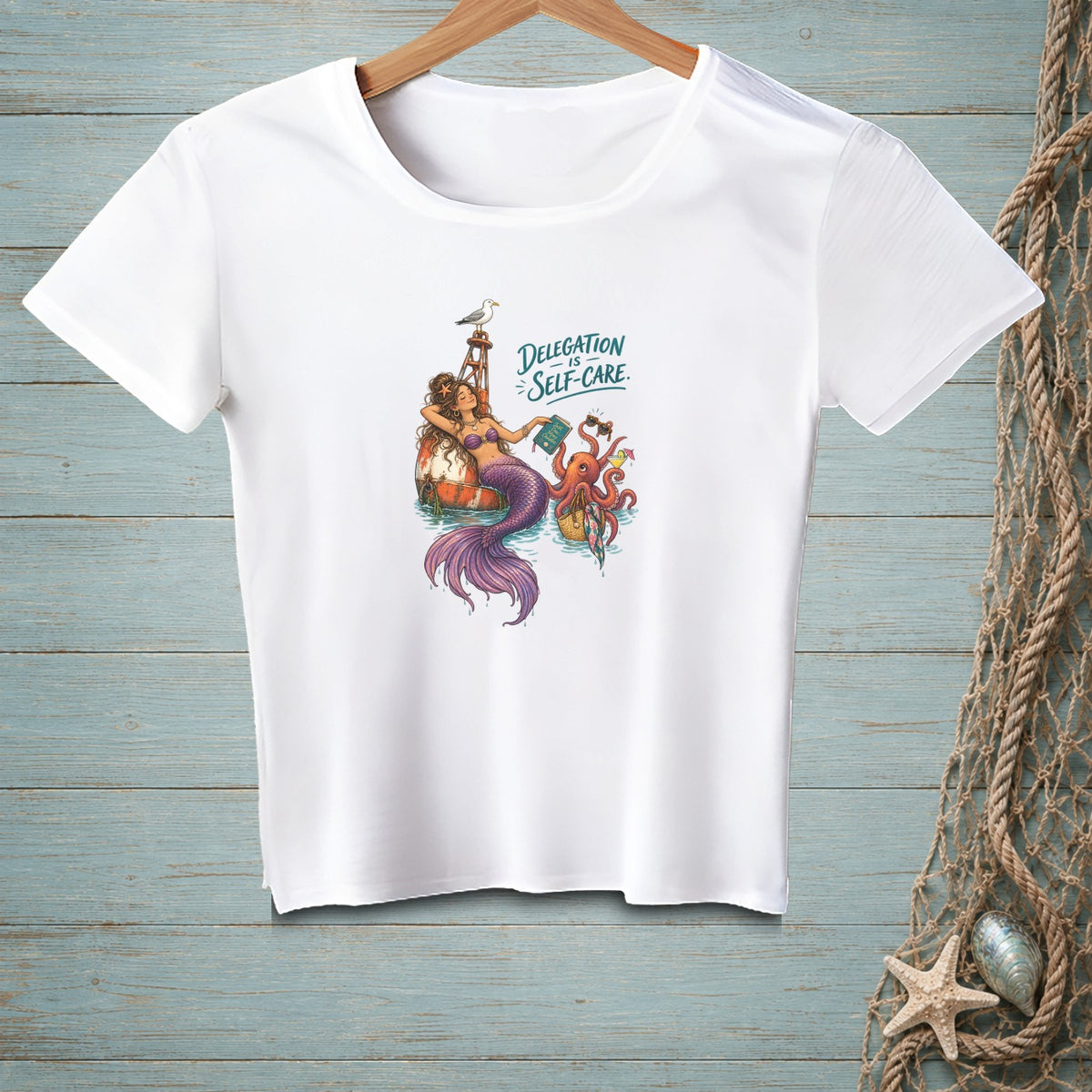 Mermaid with octopus and text "Delegation is Self-Care" on white t-shirt.