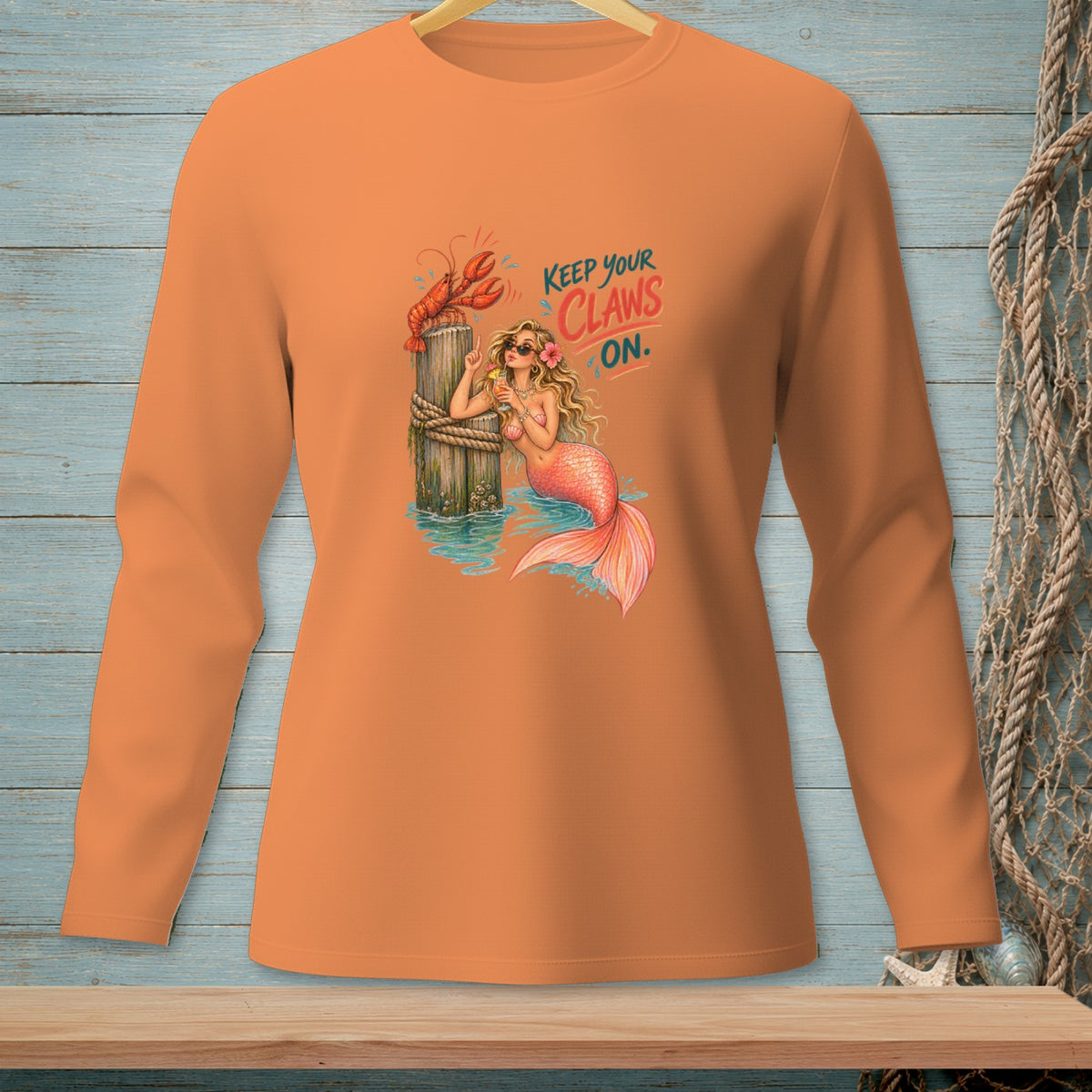 Orange long sleeve shirt with mermaid and lobster graphic saying "Keep Your Claws On".