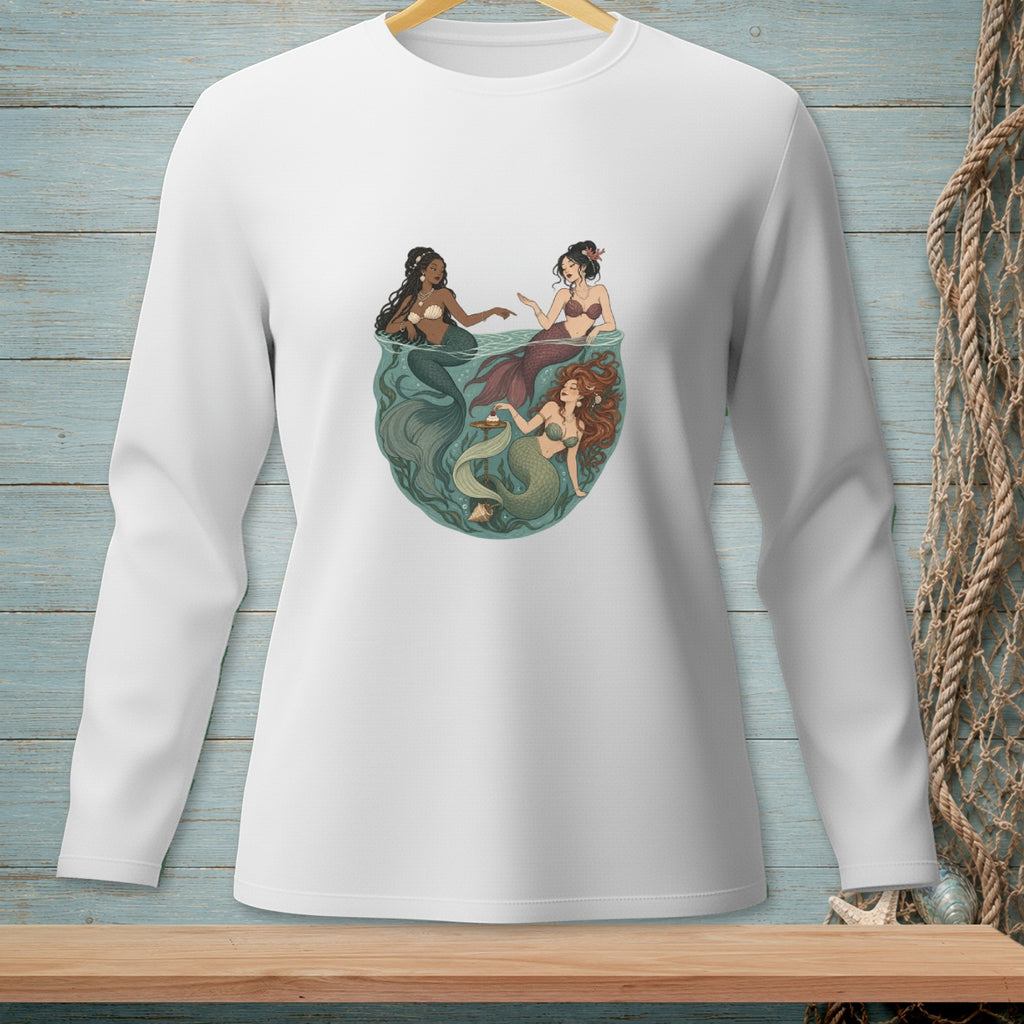 Three mermaids in a bowl of water with seaweed and seashells.