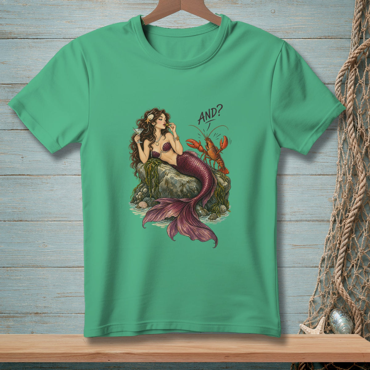 Mermaid and lobster graphic with "AND?" text on a green t-shirt.