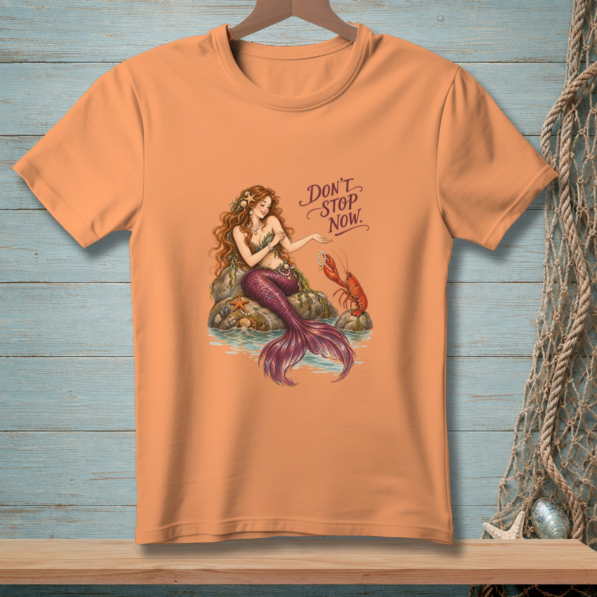 Mermaid with lobster and starfish on rocks, text "DON'T STOP NOW."