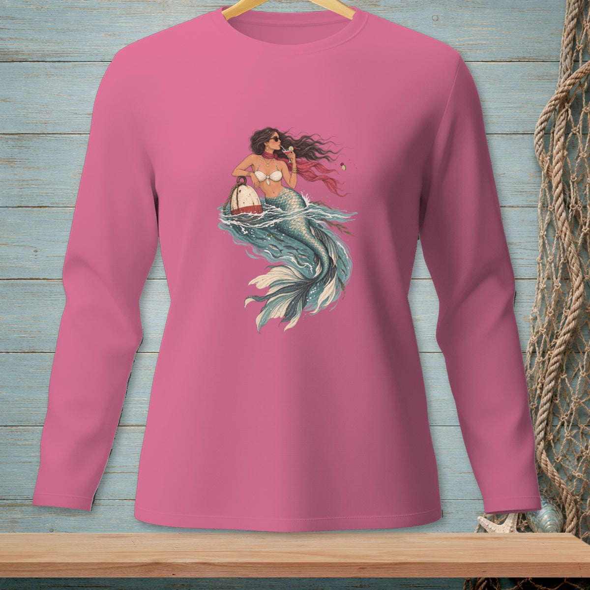 Pink long-sleeve shirt with a mermaid graphic holding a buoy and drink.