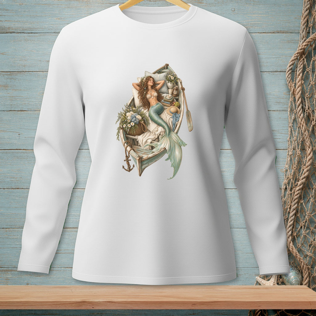 White long-sleeve shirt with a graphic of a mermaid lounging in a boat with flowers and books.