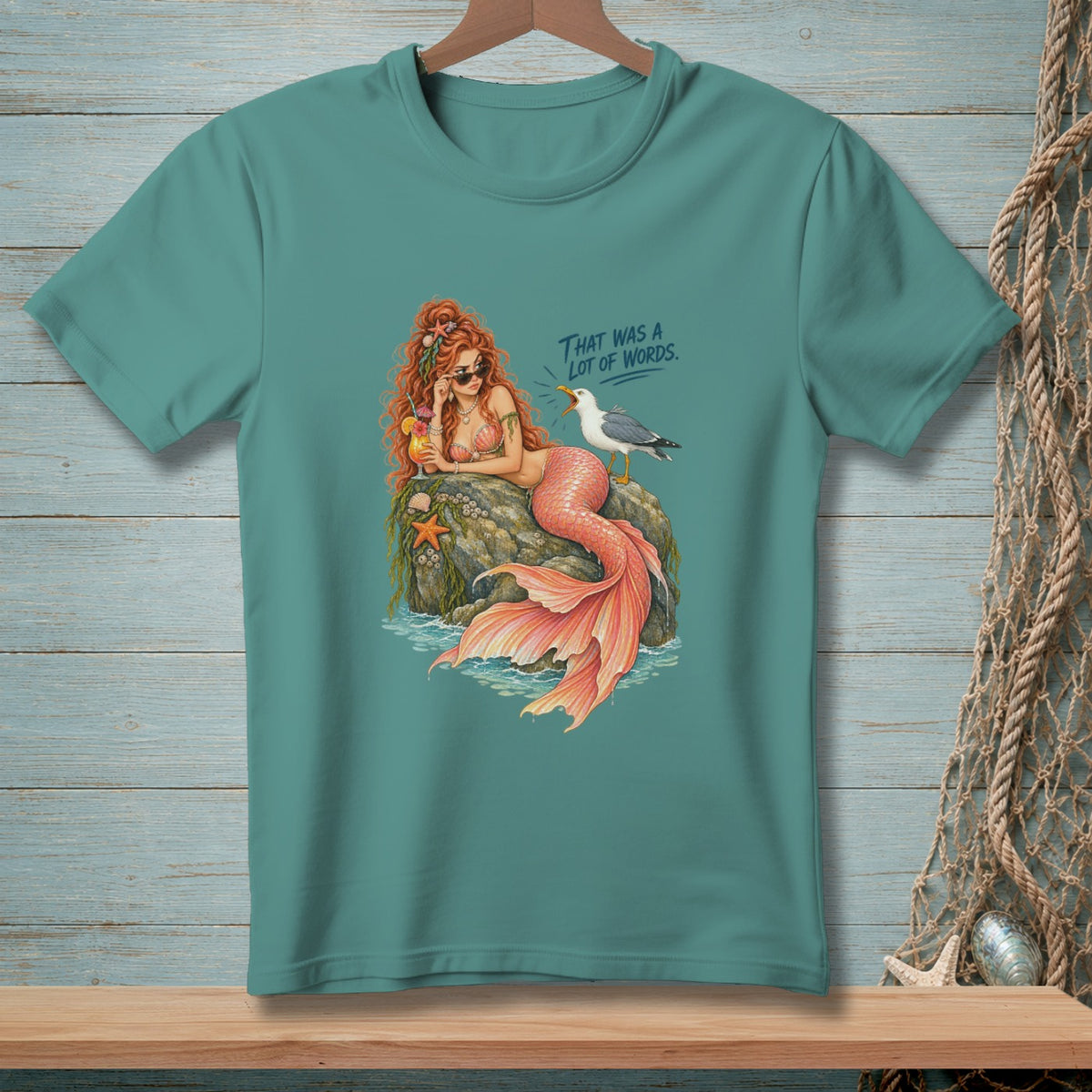 Mermaid with sunglasses sits on rock, holding a drink, with a seagull and text "THAT WAS A LOT OF WORDS."