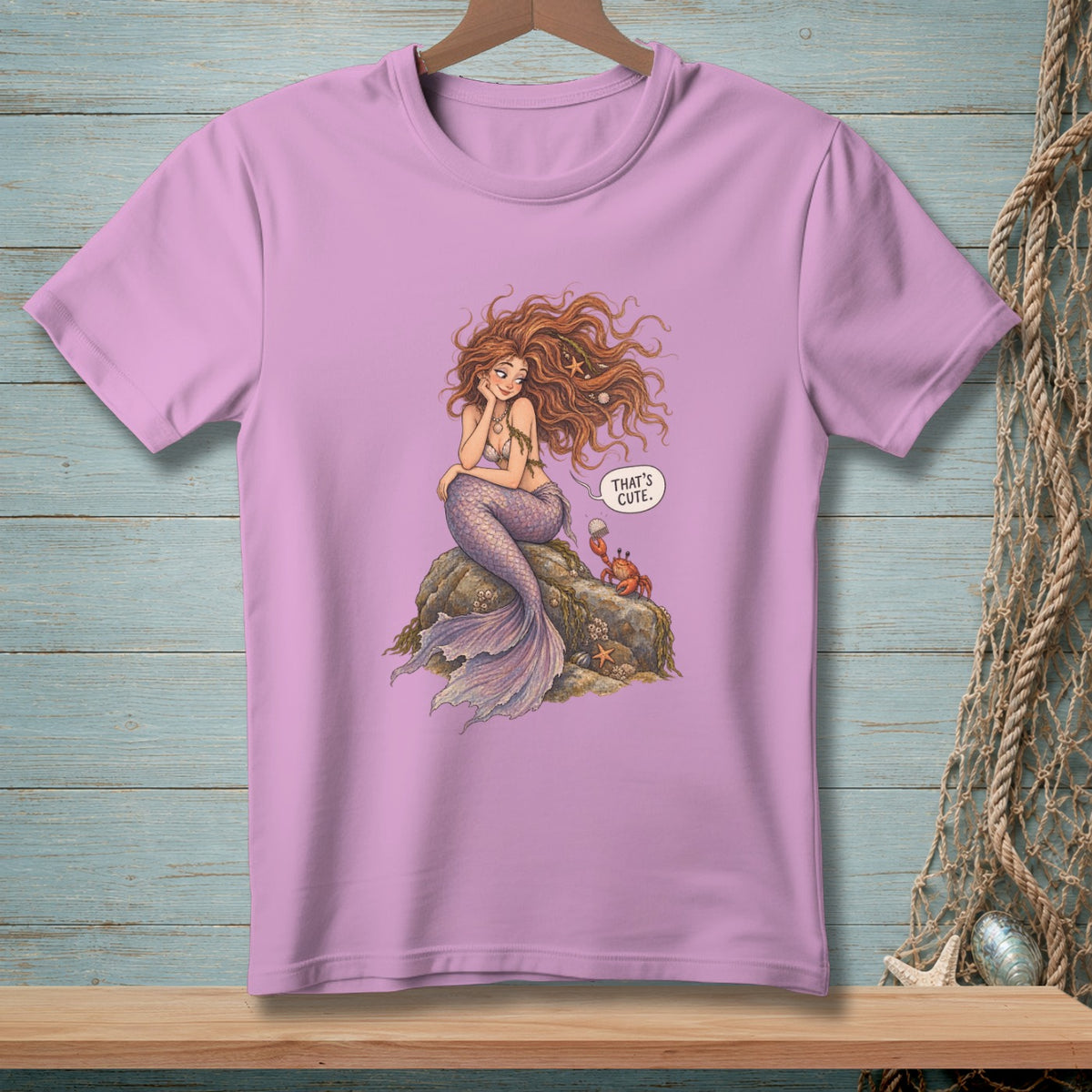 Purple t-shirt with a mermaid sitting on a rock and a crab with the text "That's cute".