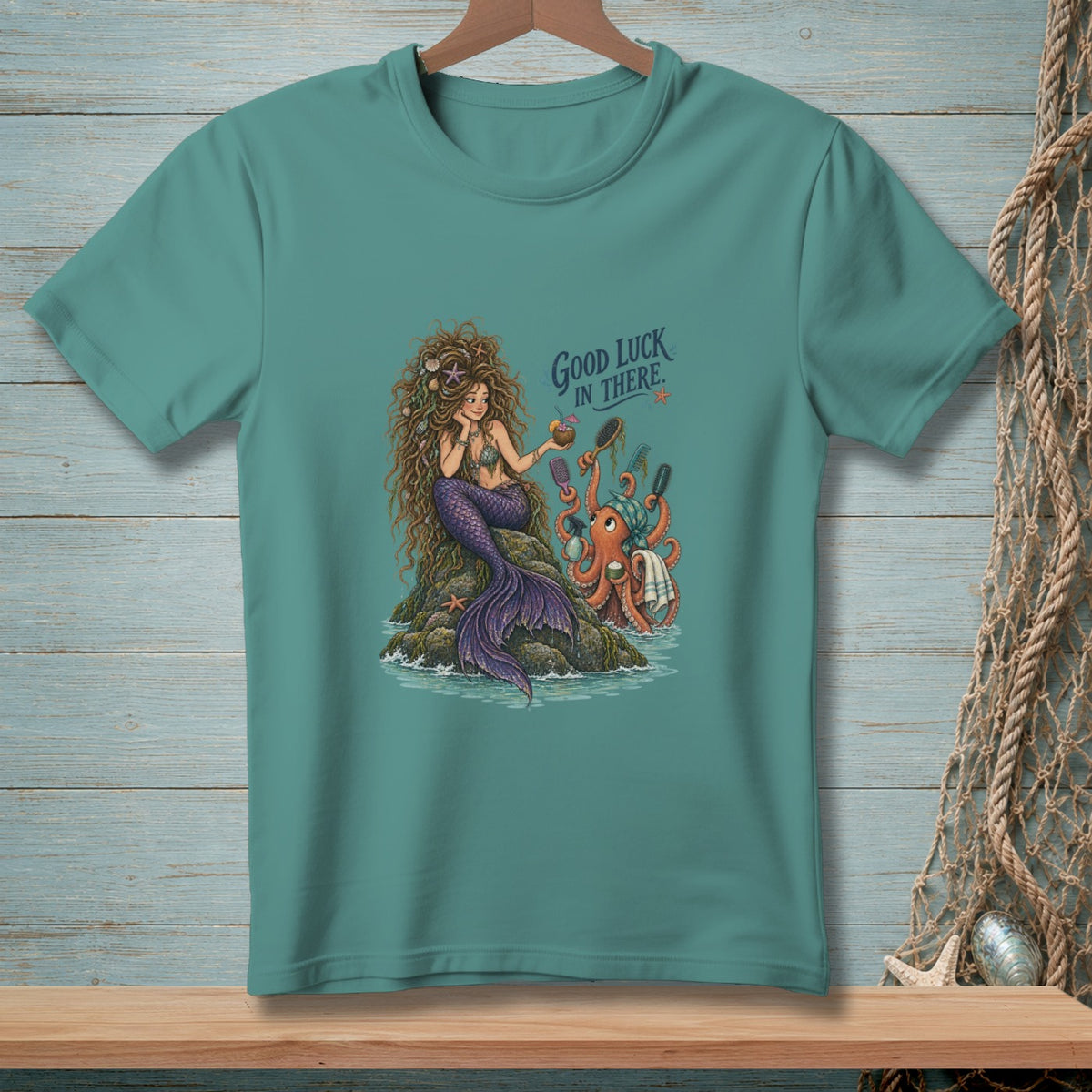 Mermaid and octopus graphic with text "Good Luck In There" on teal t-shirt.