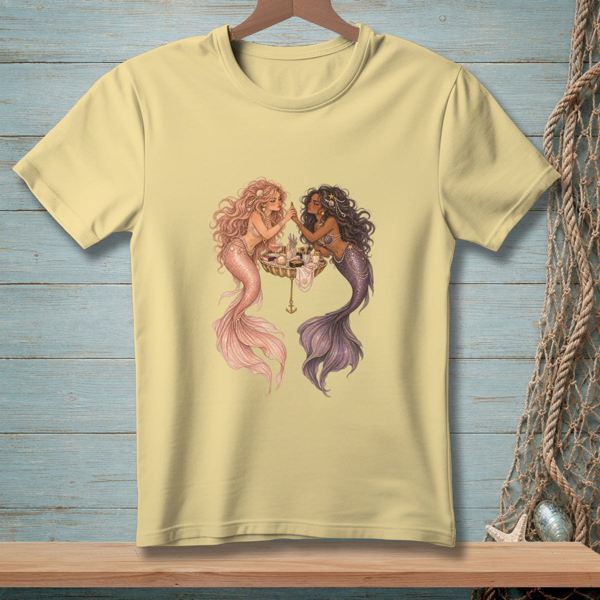 Two mermaids with colorful tails apply makeup around a seashell vanity.