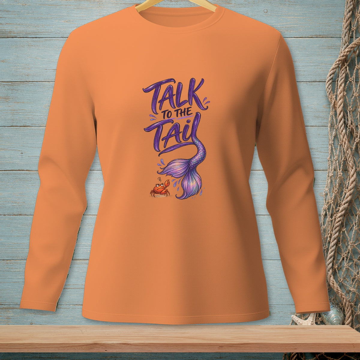 Orange long-sleeve shirt with "Talk to the Tail" text and mermaid tail illustration.