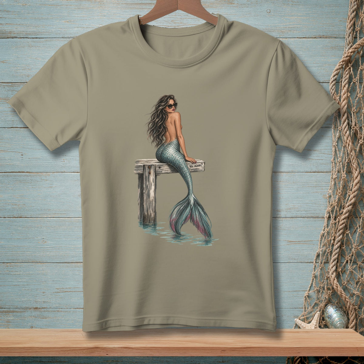 Tan t-shirt with mermaid illustration sitting on a dock, reads "YOU AGAIN?"