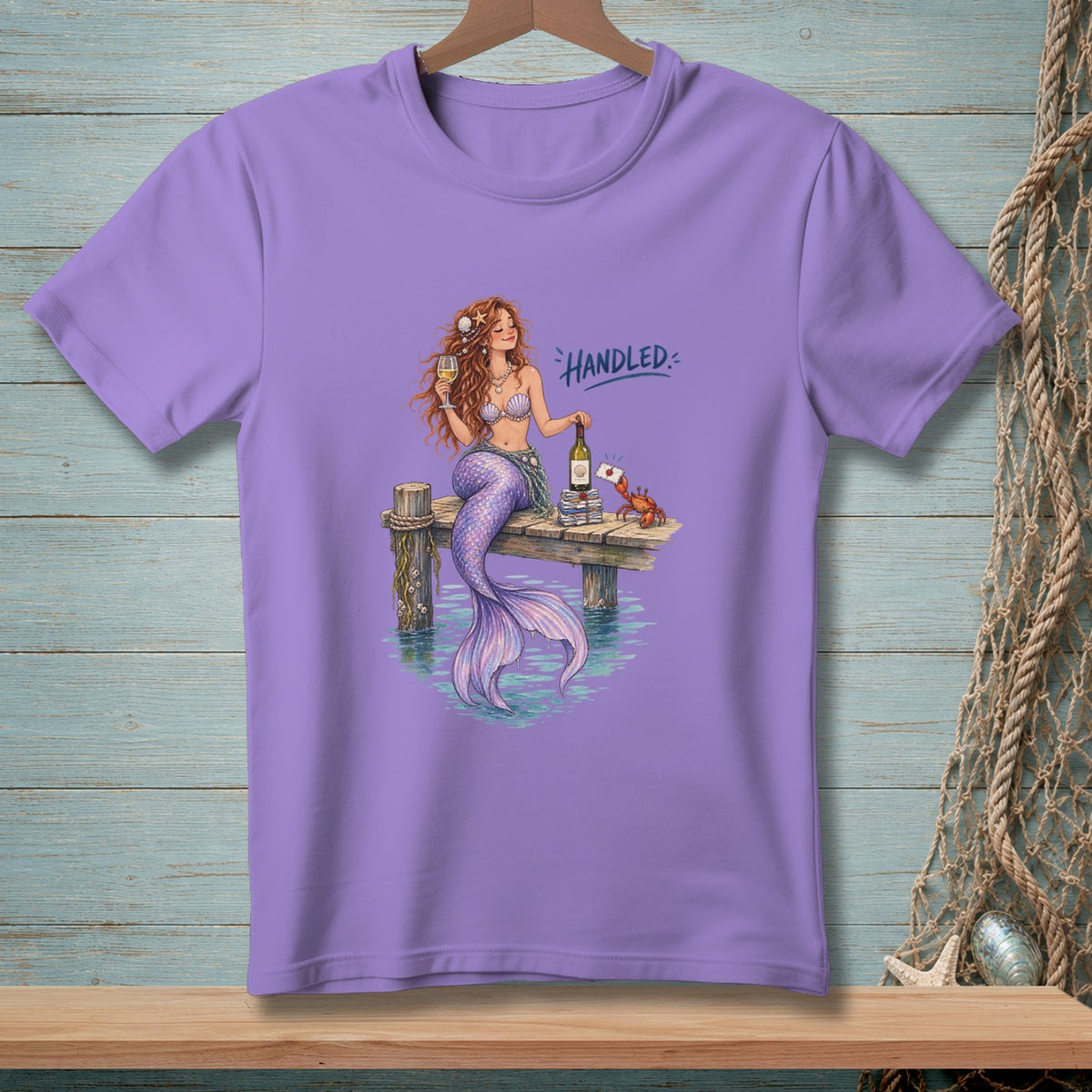 Mermaid with wine and books on a dock, with text "Handled".