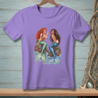 Purple t-shirt with illustration of two mermaids sitting on rocks.