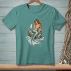 Teal t-shirt with a mermaid and seagull illustration on a rock.