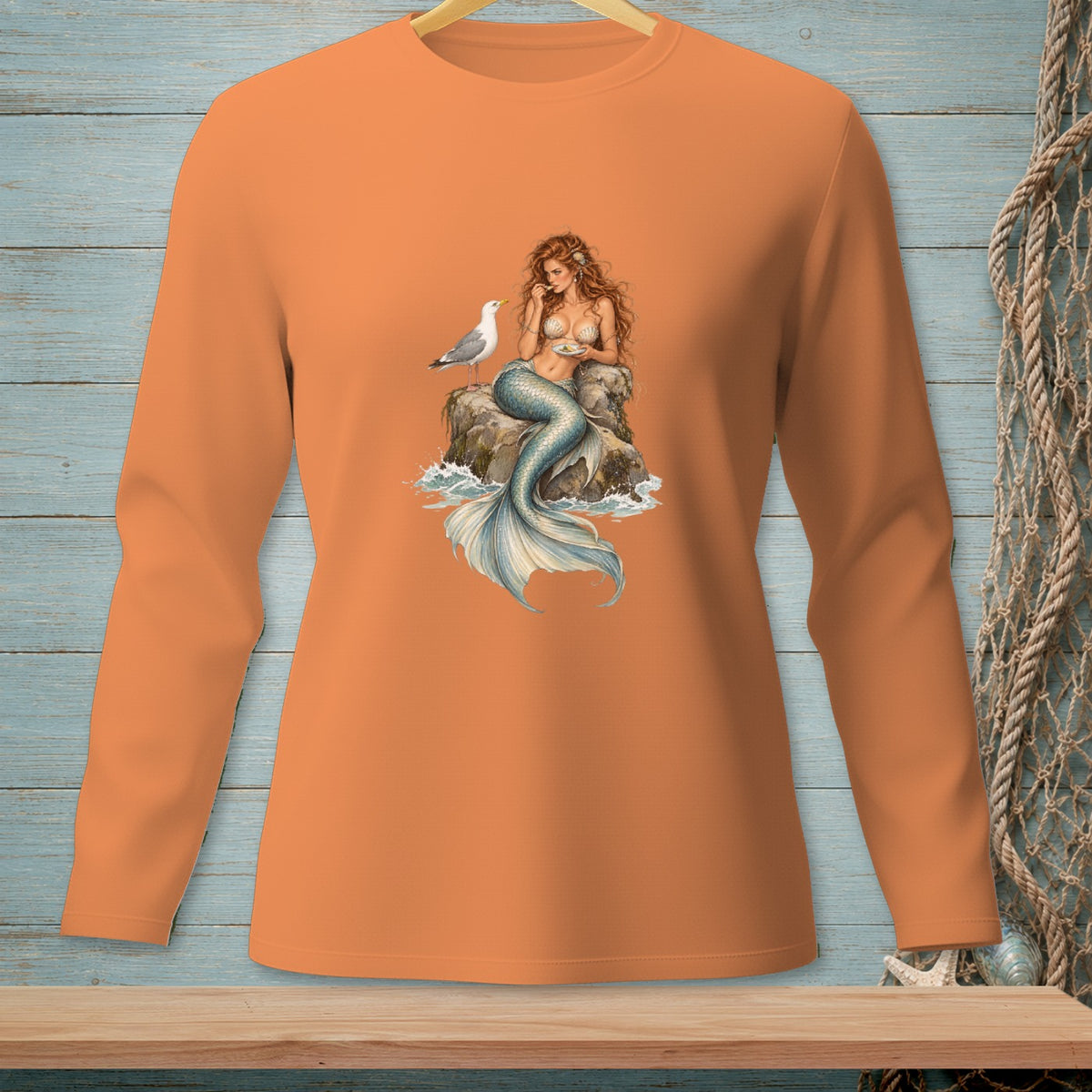 Orange long-sleeve shirt with a mermaid and seagull graphic.