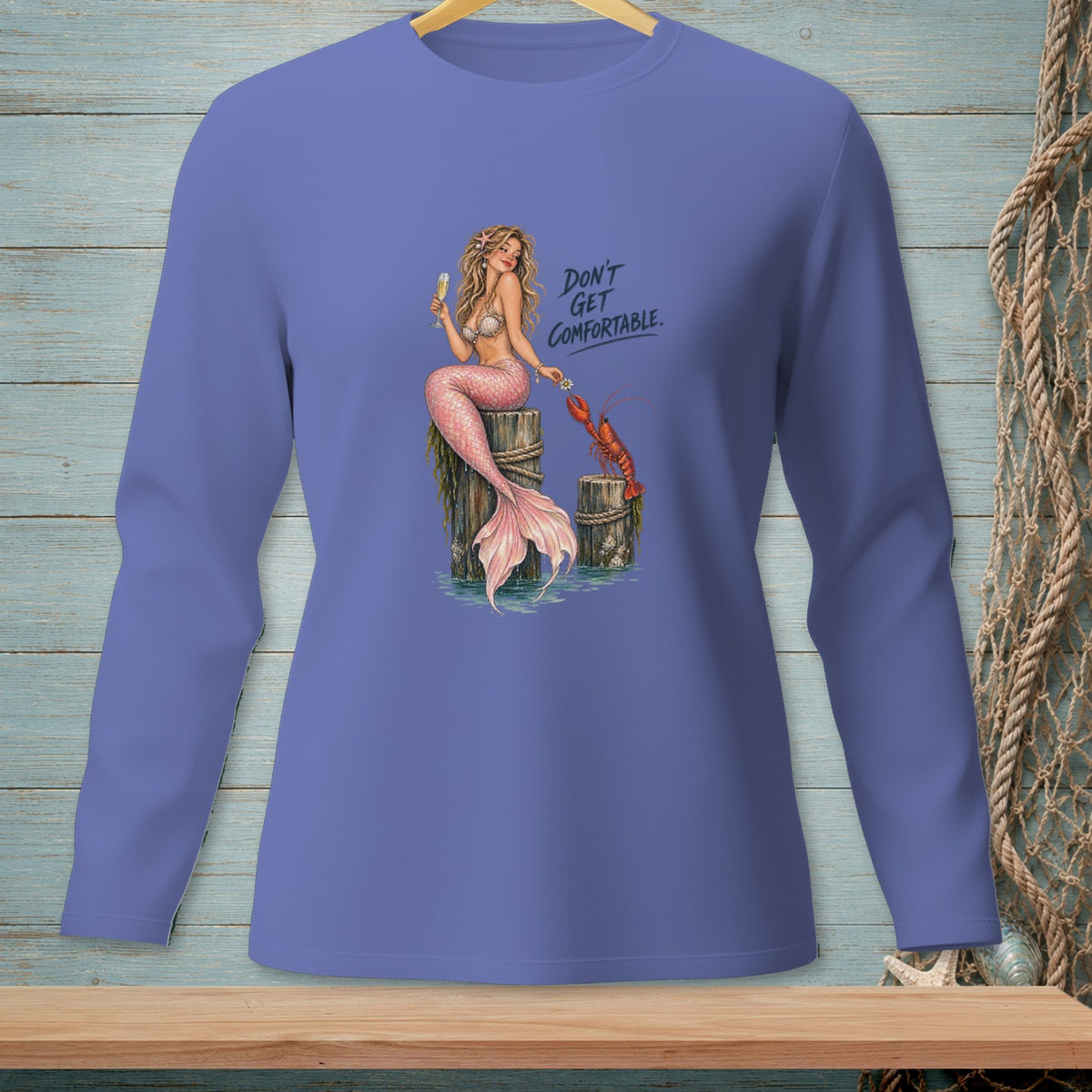 Mermaid holding a lobster and champagne, with text "Don't Get Comfortable."