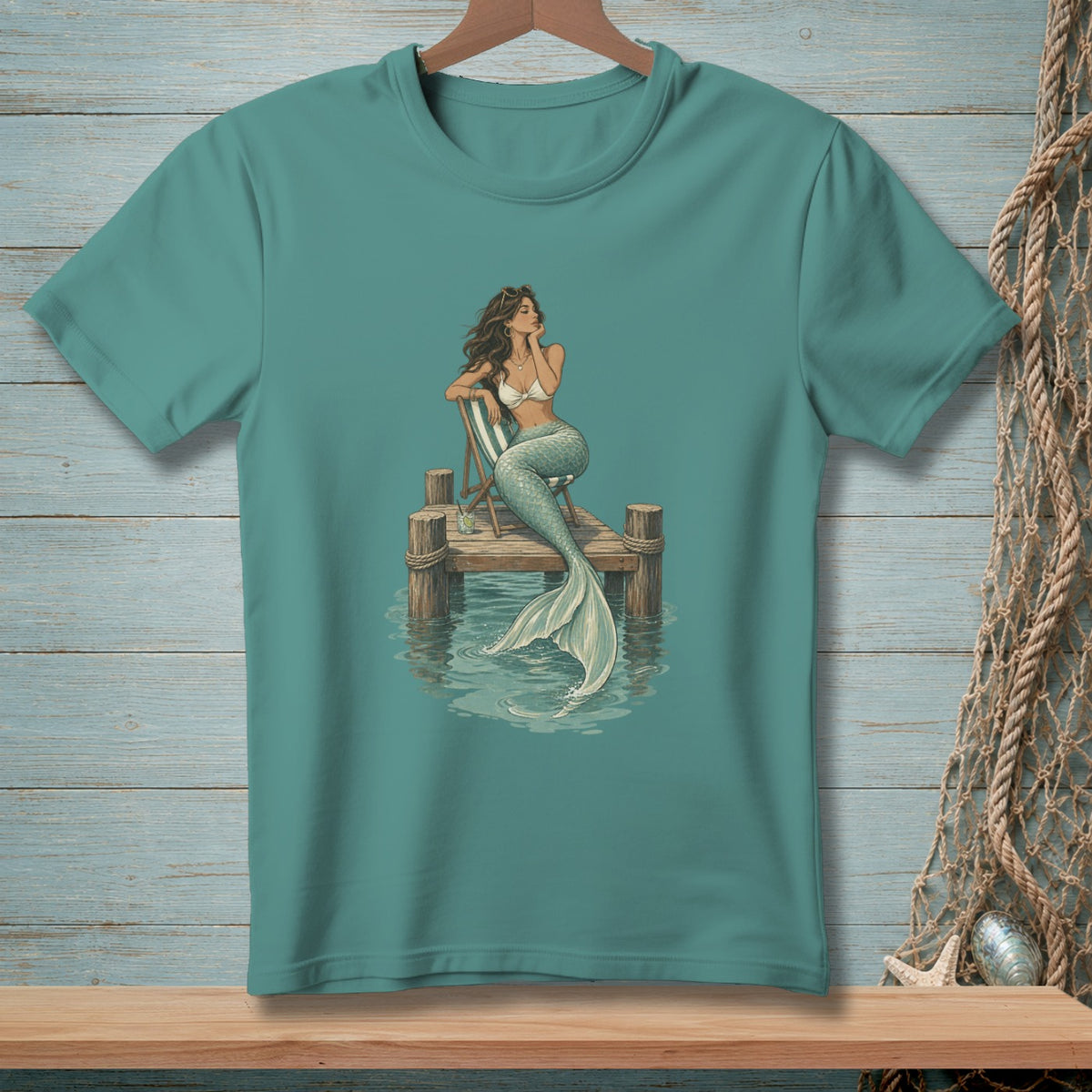 Mermaid sitting on a pier, with her tail in the water.
