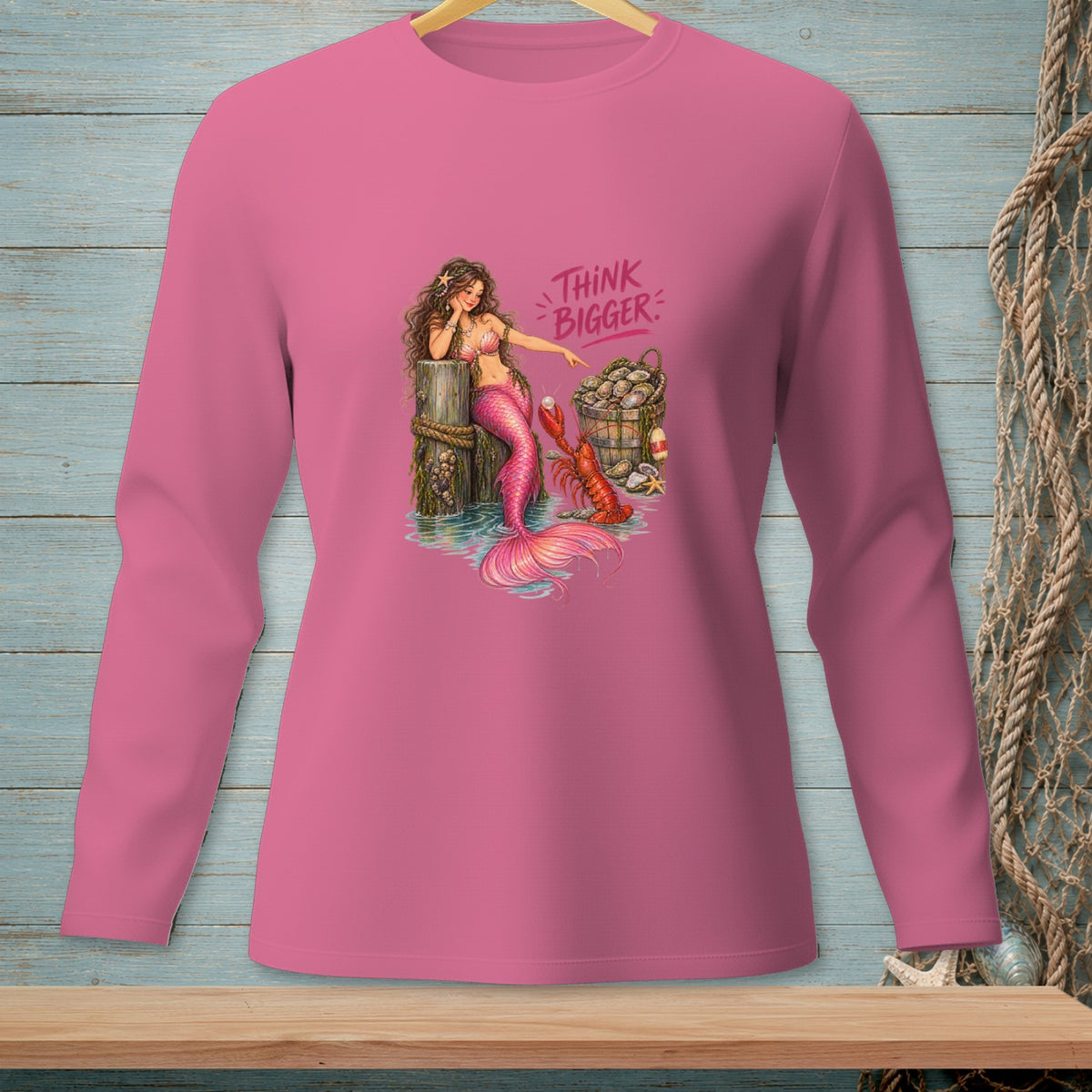 Pink long-sleeved shirt with a mermaid, lobster, and bucket of clams illustration.