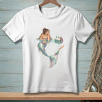 White t-shirt featuring a watercolor illustration of a mermaid in water with a cooler of bottles.