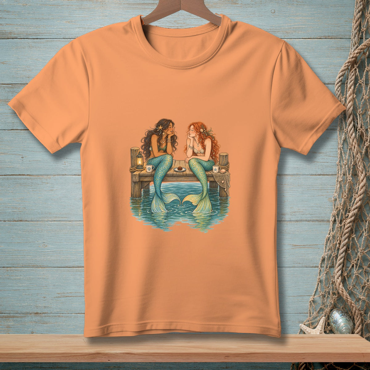 Two mermaids sit on a pier in the water, talking.
