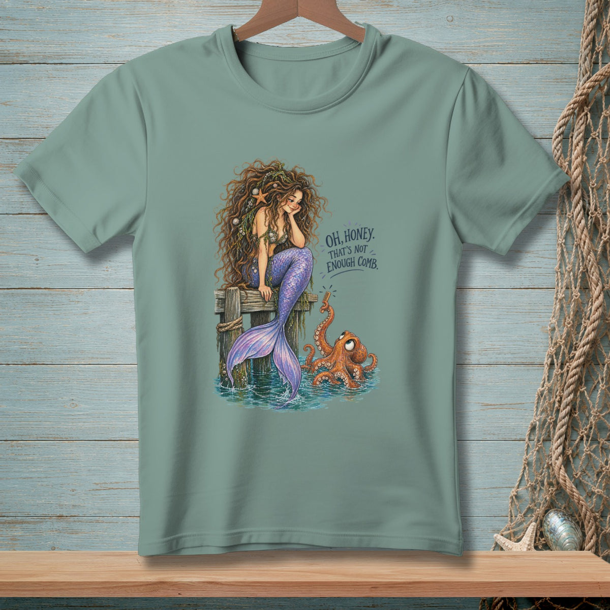 Mermaid with long, curly hair sitting on a dock with an octopus and the text "OH, HONEY. THAT'S NOT ENOUGH COMB."