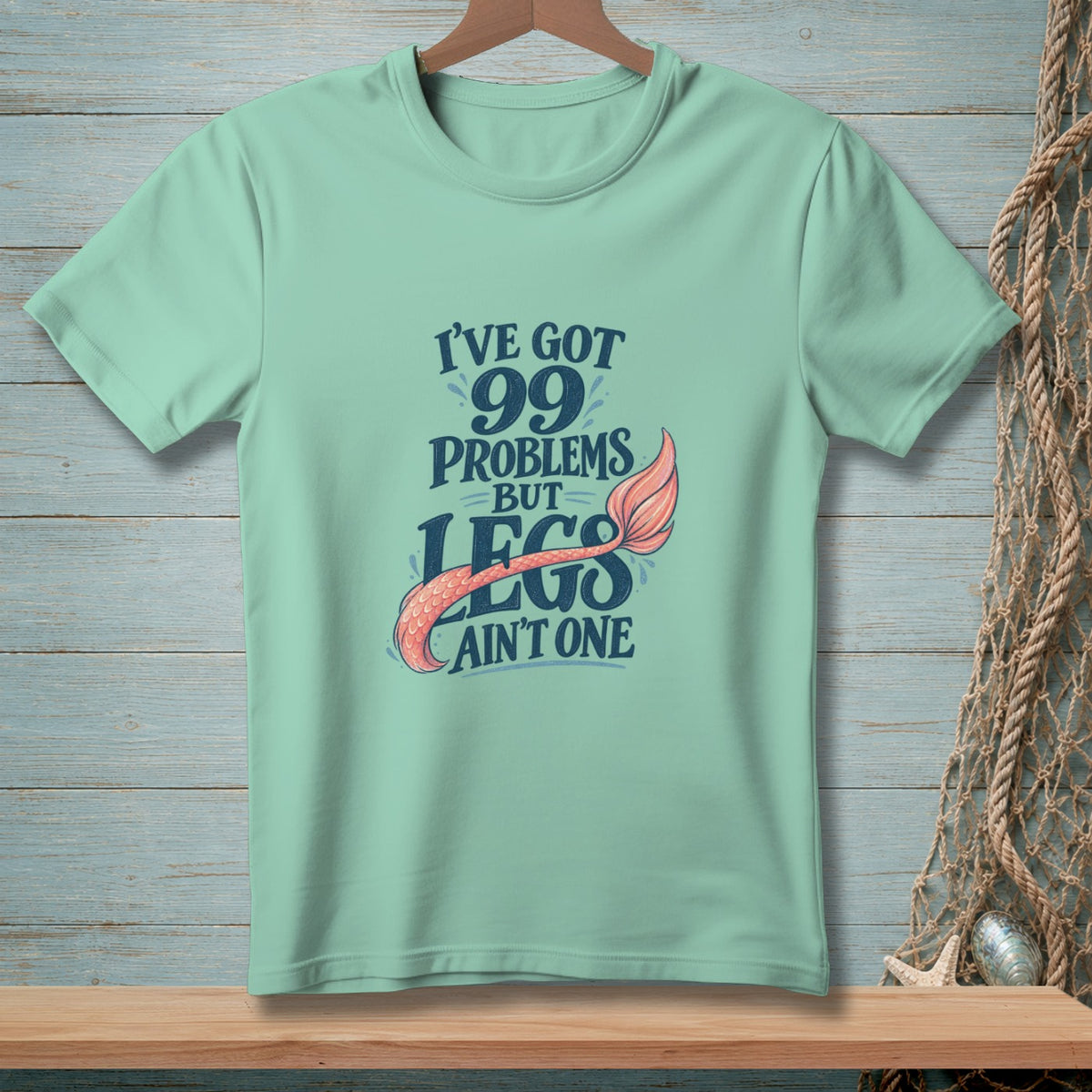 Mint t-shirt with "I've Got 99 Problems But Legs Ain't One" text and mermaid tail.