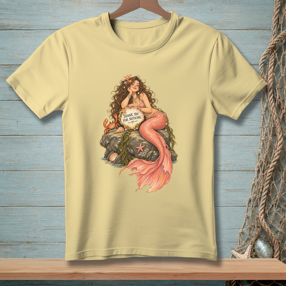 Mermaid sitting on a rock with a crab holding a sign that reads "Thank you for noticing."