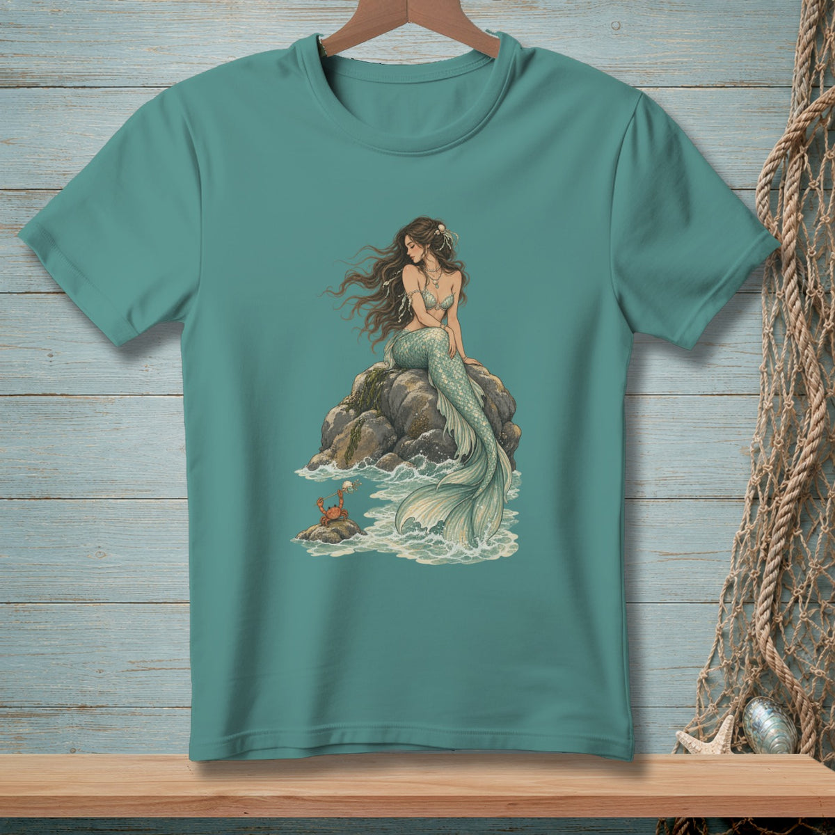 Mermaid sitting on rocks with a crab, detailed illustration on a teal t-shirt.