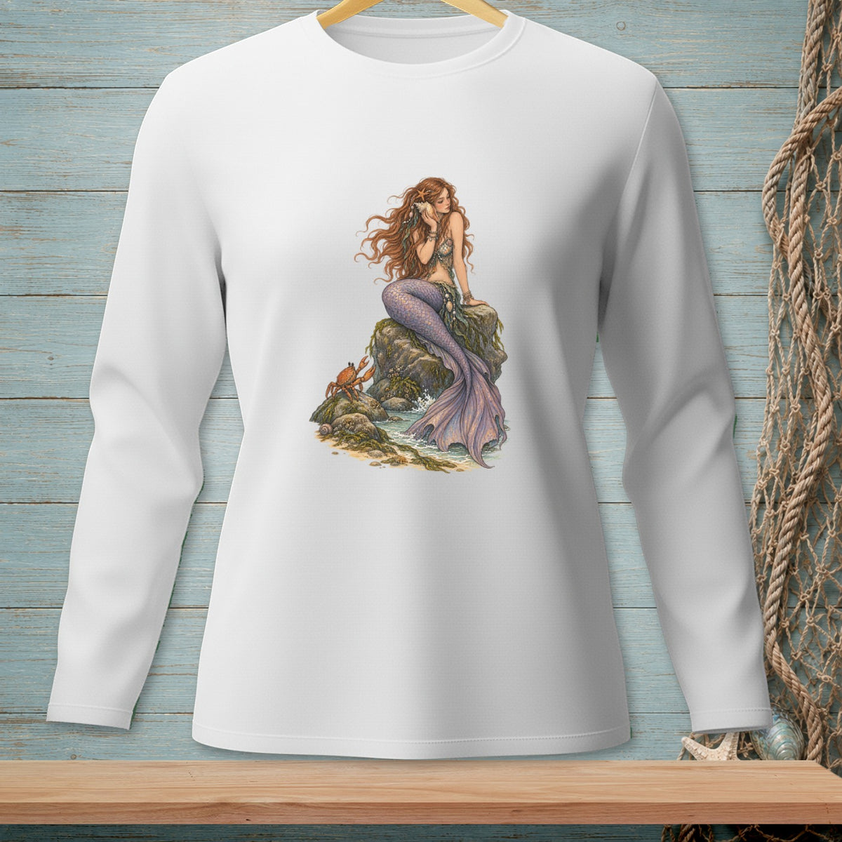 White long-sleeve shirt with a mermaid sitting on rocks with a crab.