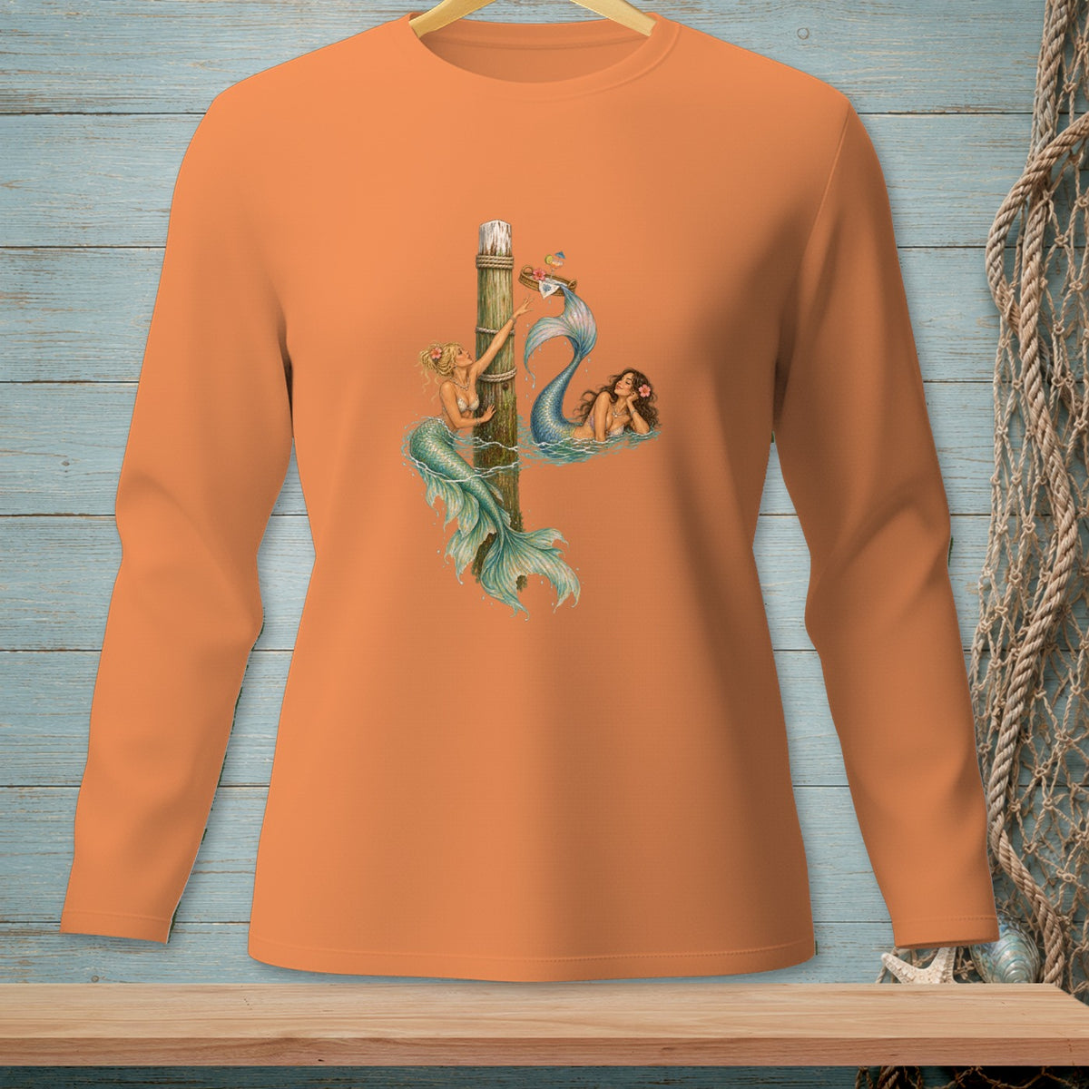 Orange long-sleeve shirt with two mermaids and a nautical theme graphic.