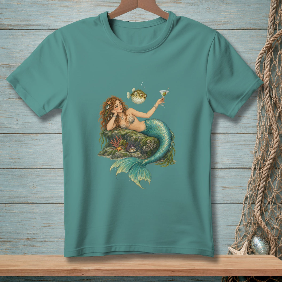Mermaid reclines on rock with martini, puff fish watches nearby.