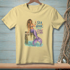 Mermaid with champagne on pier, text "SEA HAIR ZERO CARE".