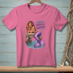 Pink t-shirt with a mermaid on a dock, text "SALTY, TANGLED & UNBOTHERED."