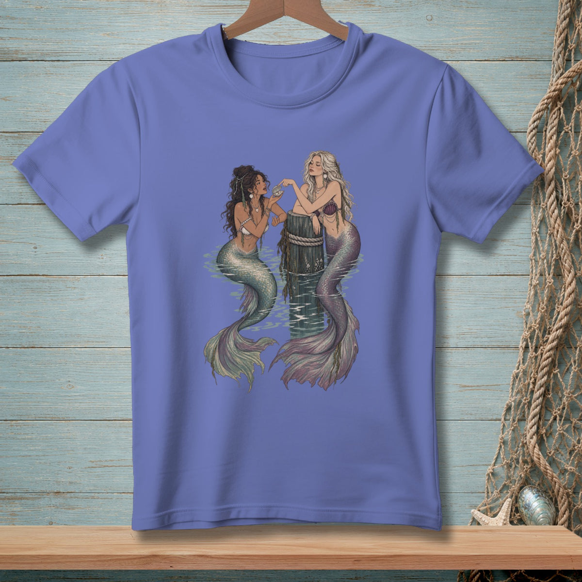 Two mermaids interact next to a wooden post in the water.