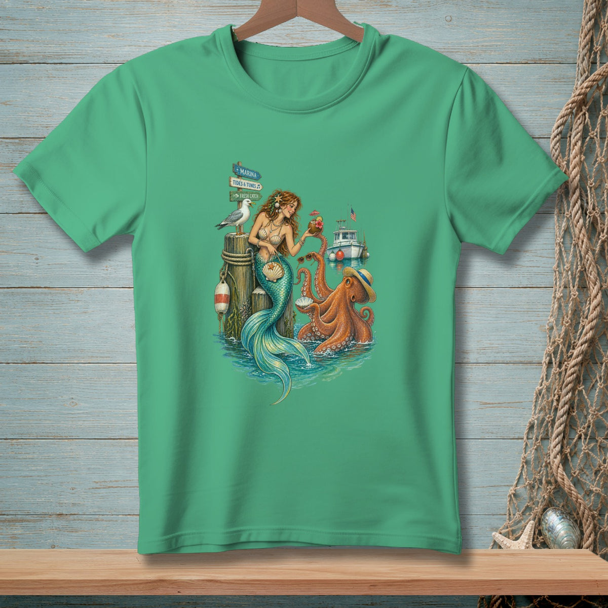 Mermaid, octopus, and seagull scene with a boat and marina sign on a green t-shirt.