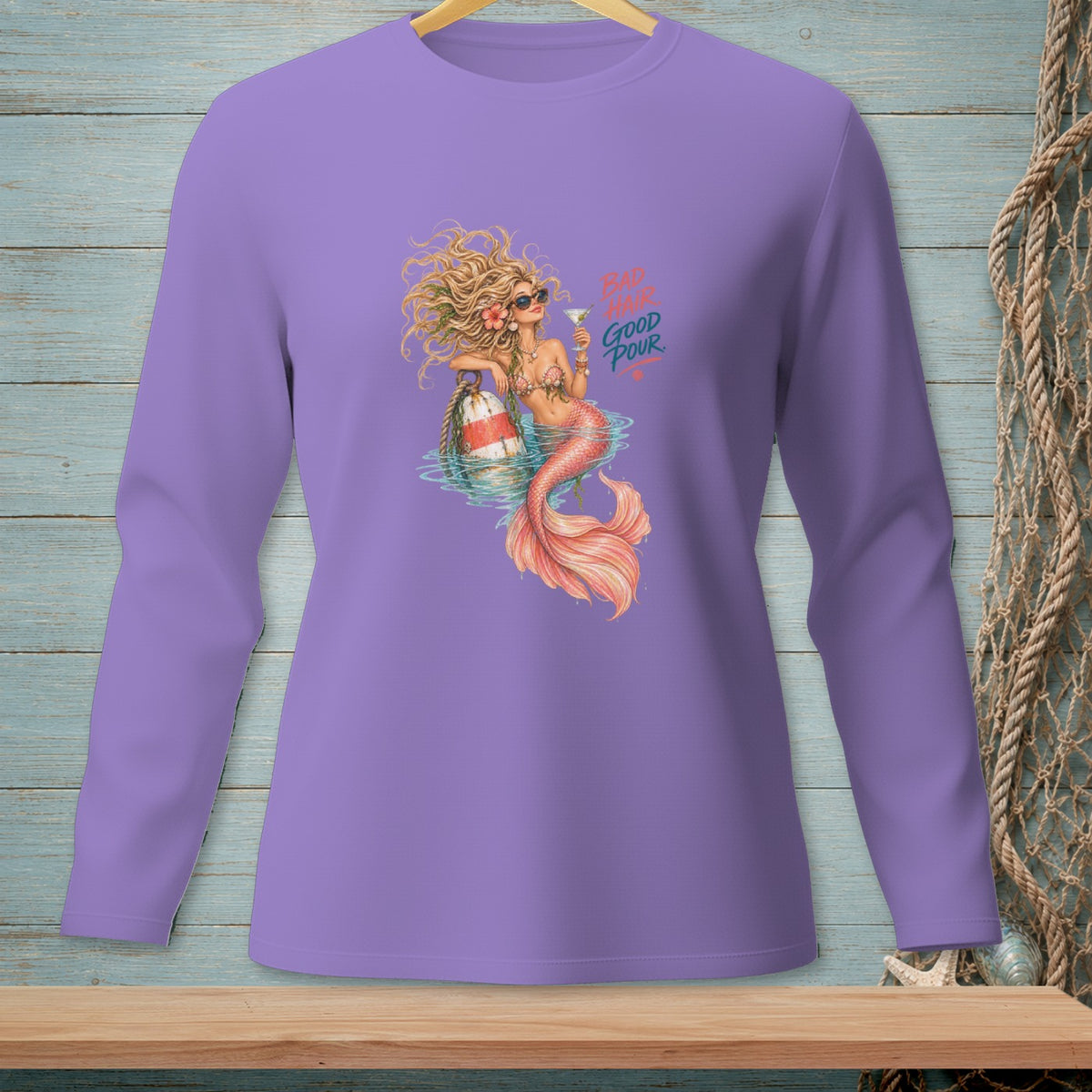Mermaid with cocktail and buoy, text "BAD HAIR GOOD POUR" on purple shirt.