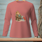 Mermaid sitting on rocks with a lobster by the water, wearing a long-sleeved coral shirt.