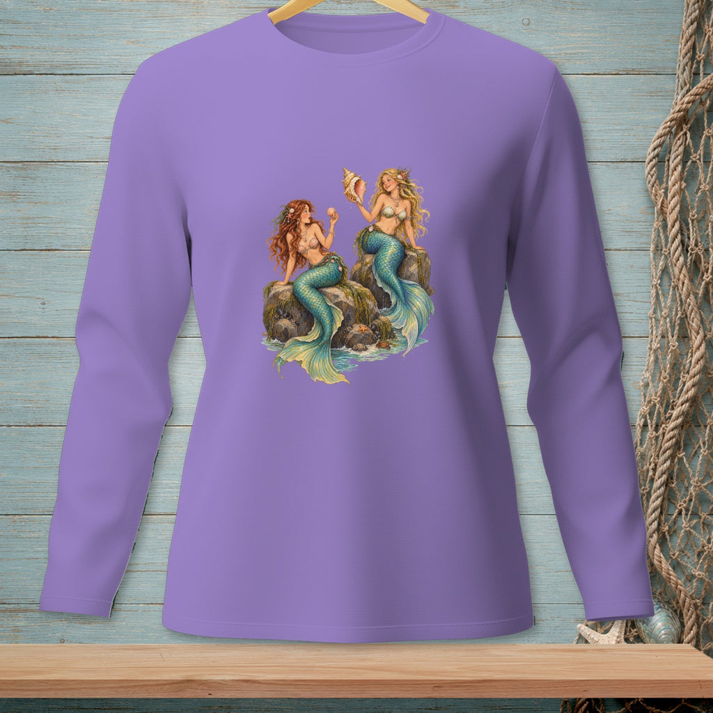 Lavender long-sleeve shirt with two mermaids sitting on rocks holding seashells.