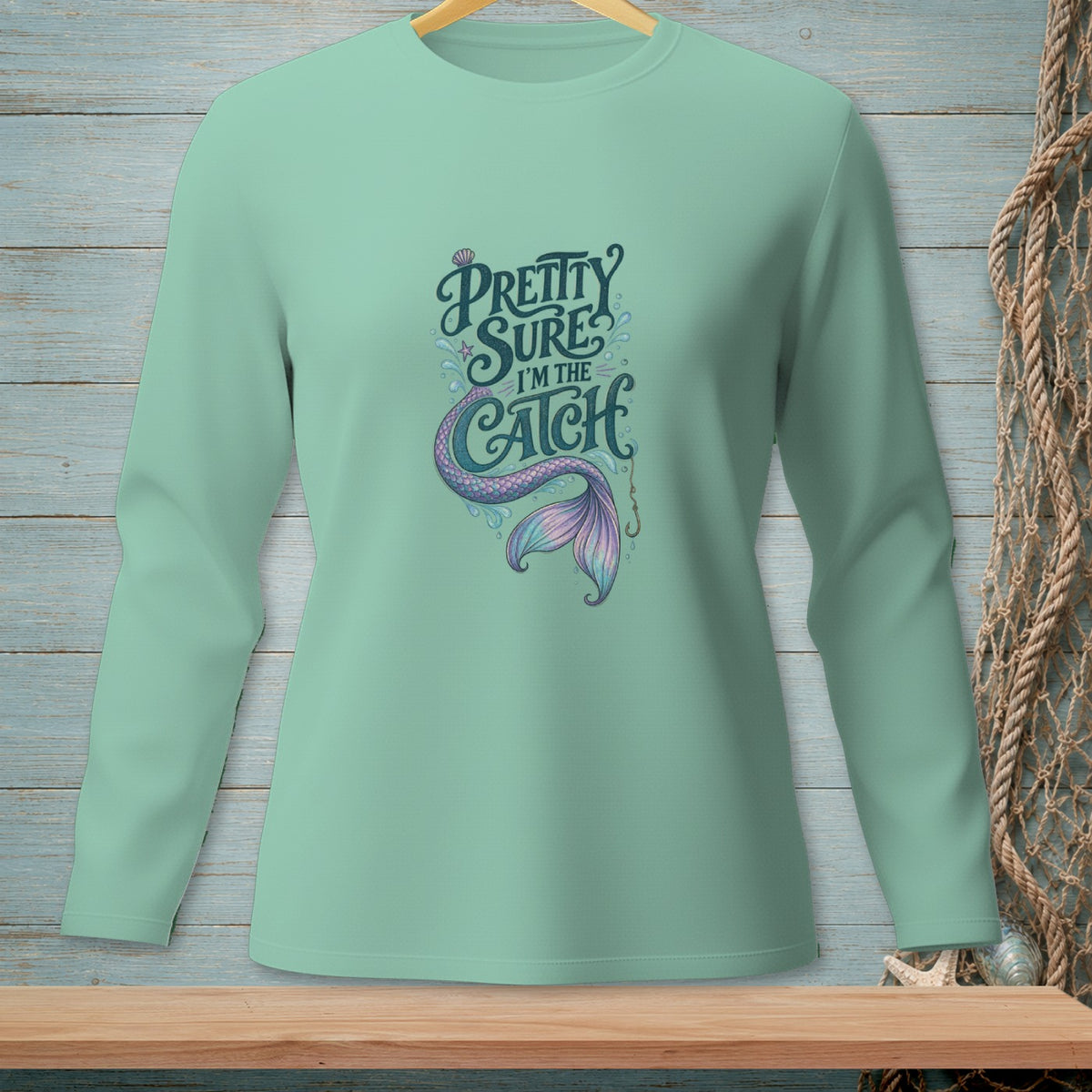 Mint green long-sleeve shirt with "Pretty Sure I'm the Catch" and a mermaid tail graphic.