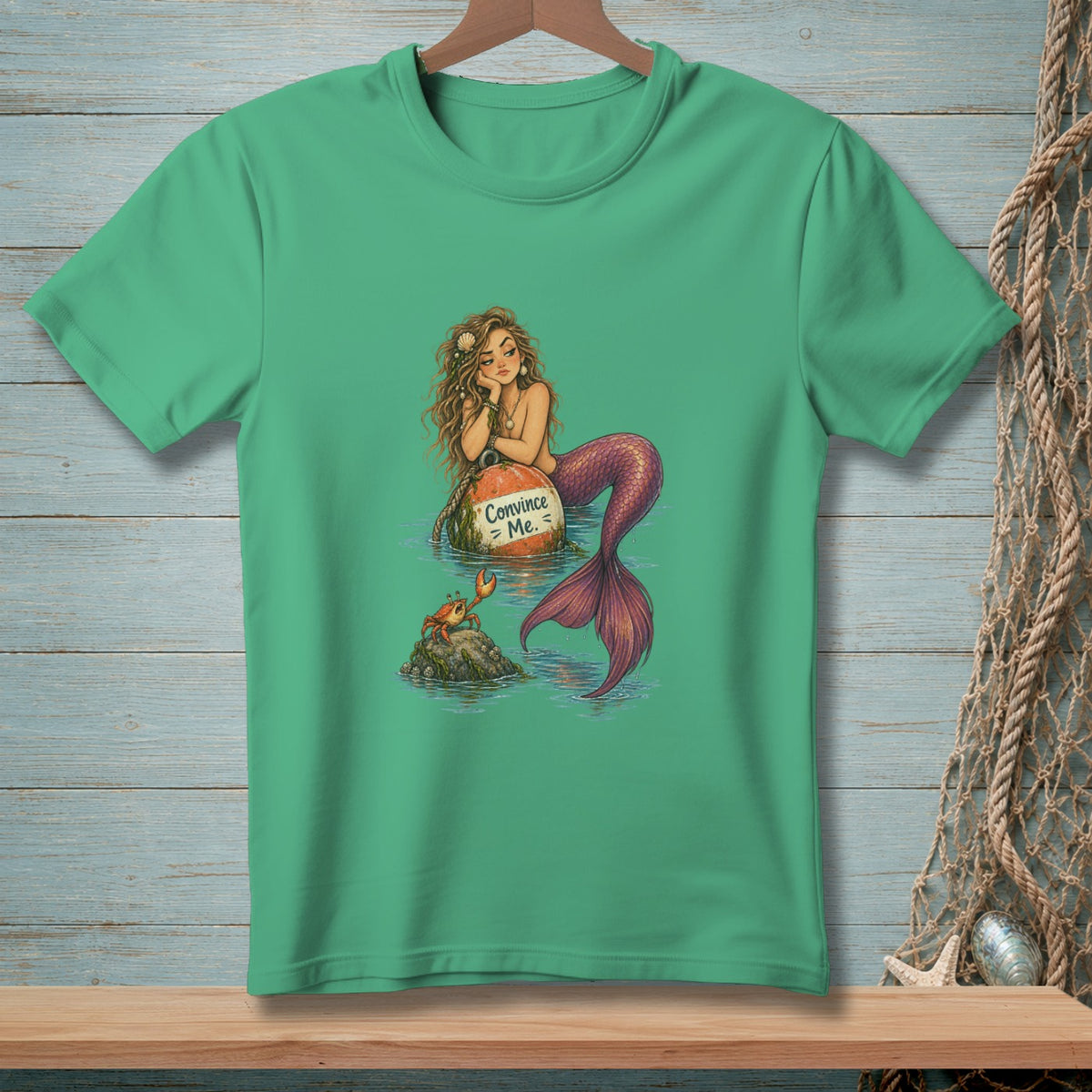 Mermaid rests on a buoy with "Convince Me." text, looking at a crab.