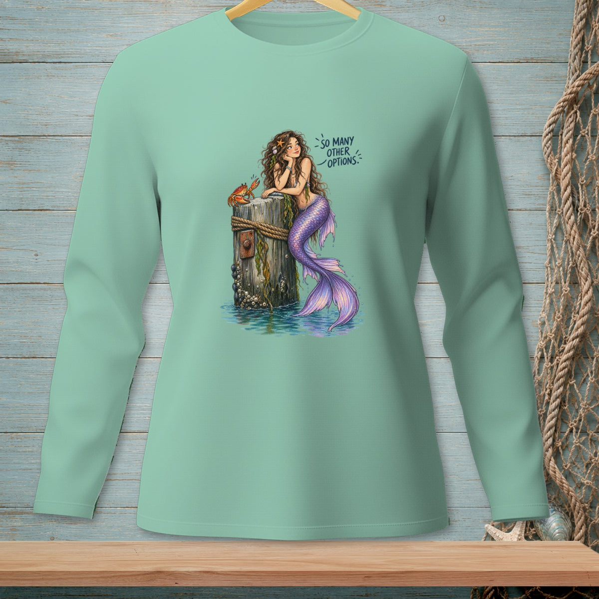 Mint long sleeve shirt with mermaid and crab graphic and text "so many other options".
