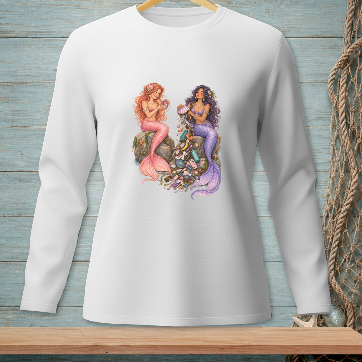 Two mermaids sit on rocks surrounded by treasures and trinkets.