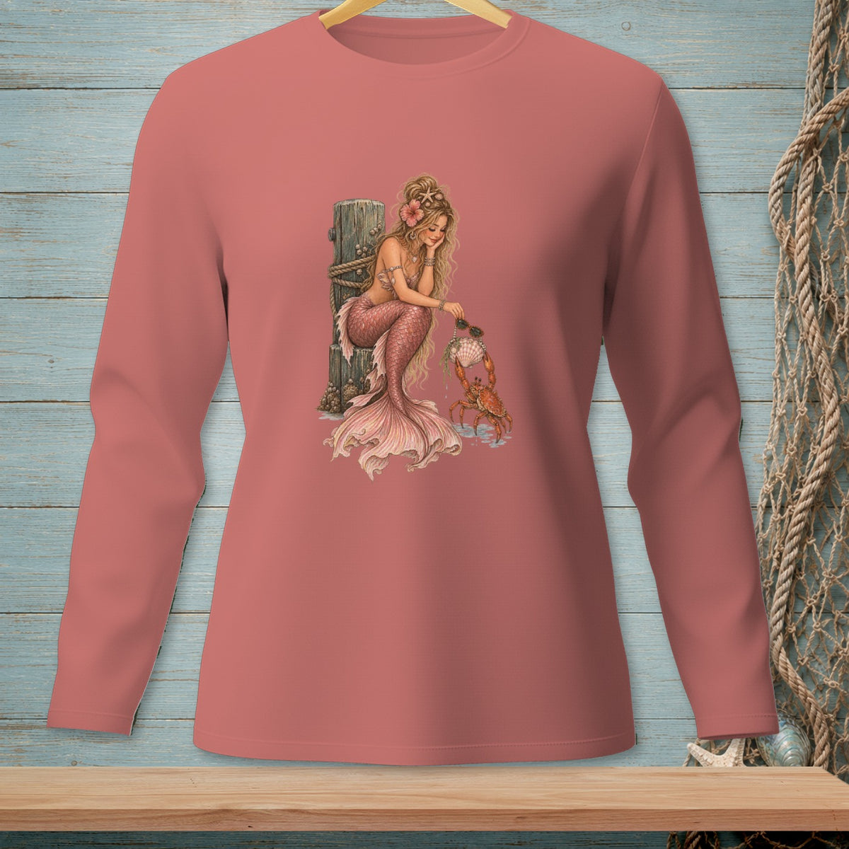 Mermaid with pink tail sitting by a post with a crab holding a seashell.