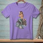 Purple t-shirt with illustration of a mermaid holding a conch shell on rocks.