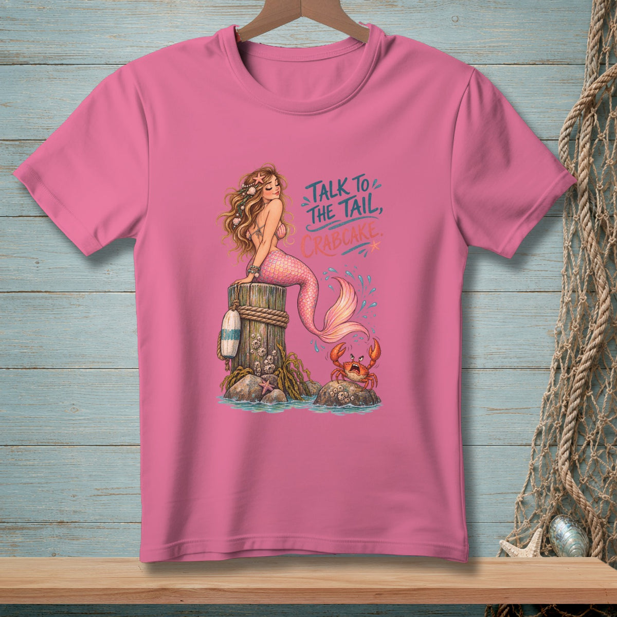 Mermaid sitting on a post with crab and text "Talk to the Tail, Crabcake."