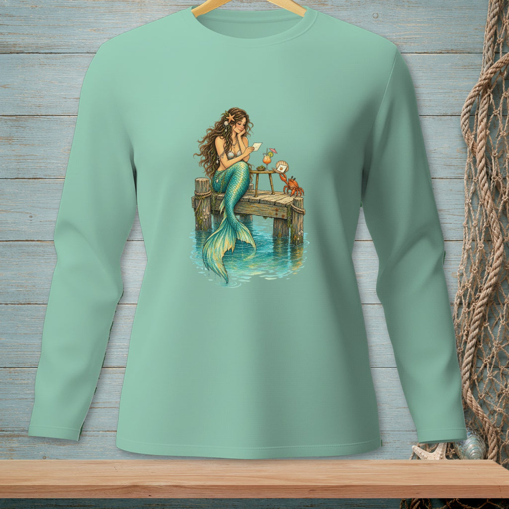 Mermaid reading a letter on a dock with a crab and drinks.