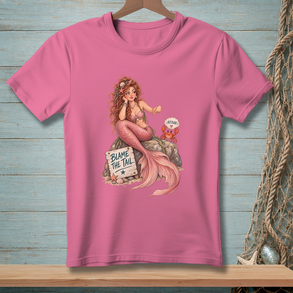 Pink t-shirt with a mermaid sitting on a rock next to a crab and sign.