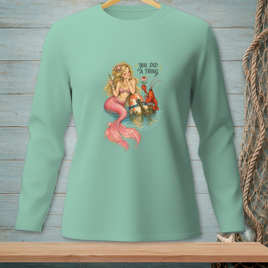Mermaid with lobster and text "YOU DID A THING." on a mint long-sleeve shirt.